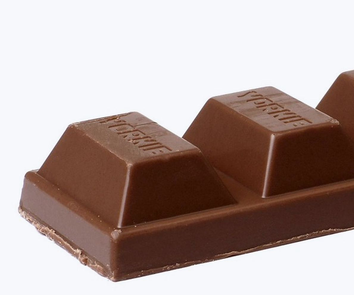 Manos preparando moldes para chocolate en la mesa de trabajo